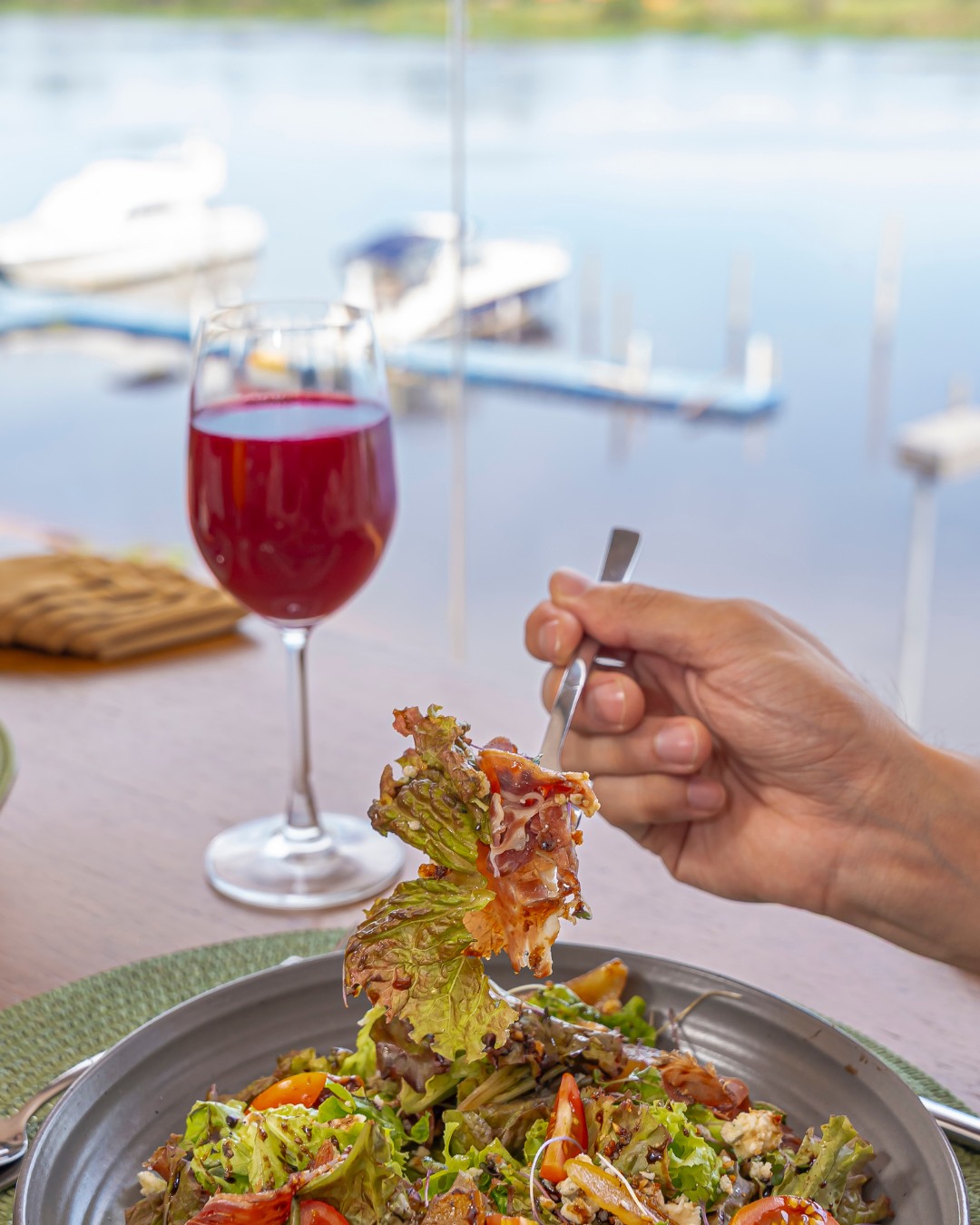 Ensalada gourmet con copa y vista a la marina