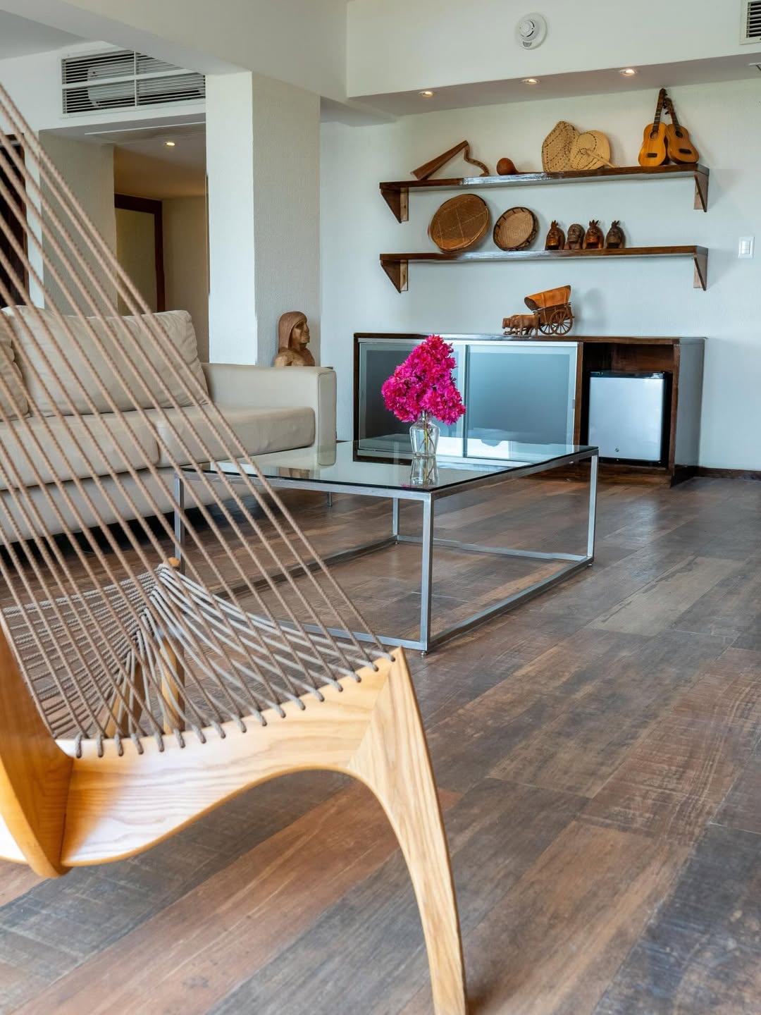 Lounge interior de habitación con muebles cálidos y vista al río