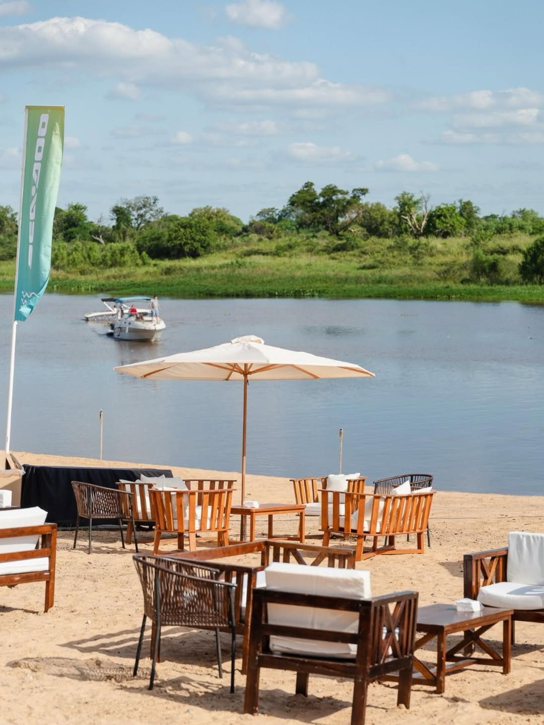 Lounge de madera sobre la arena a orillas del río